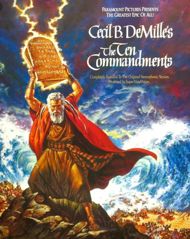 Moses is holding the tablets inscribed by lightning with the ten commandments over his head