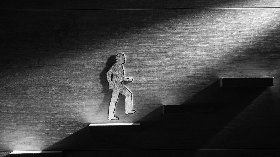 A paper figure walking up steps towards a light in the dark. Depicting how setting targets illuminates the path you need to take.