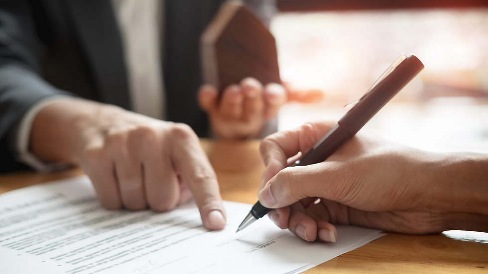 A hand holding a pen signing a contract while another hand points to where it should be signed.